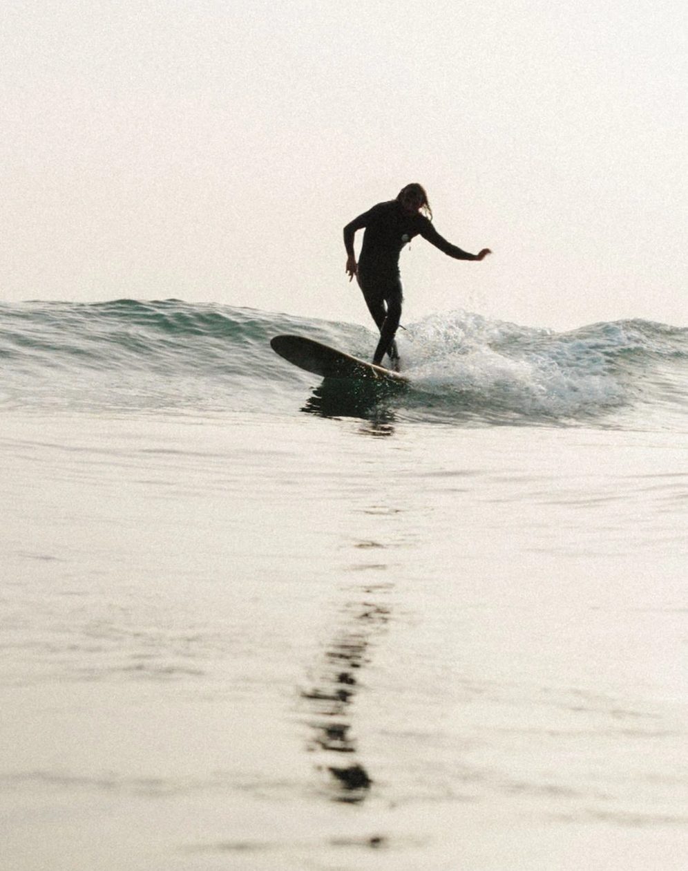 A surfer walking out at the end of the session