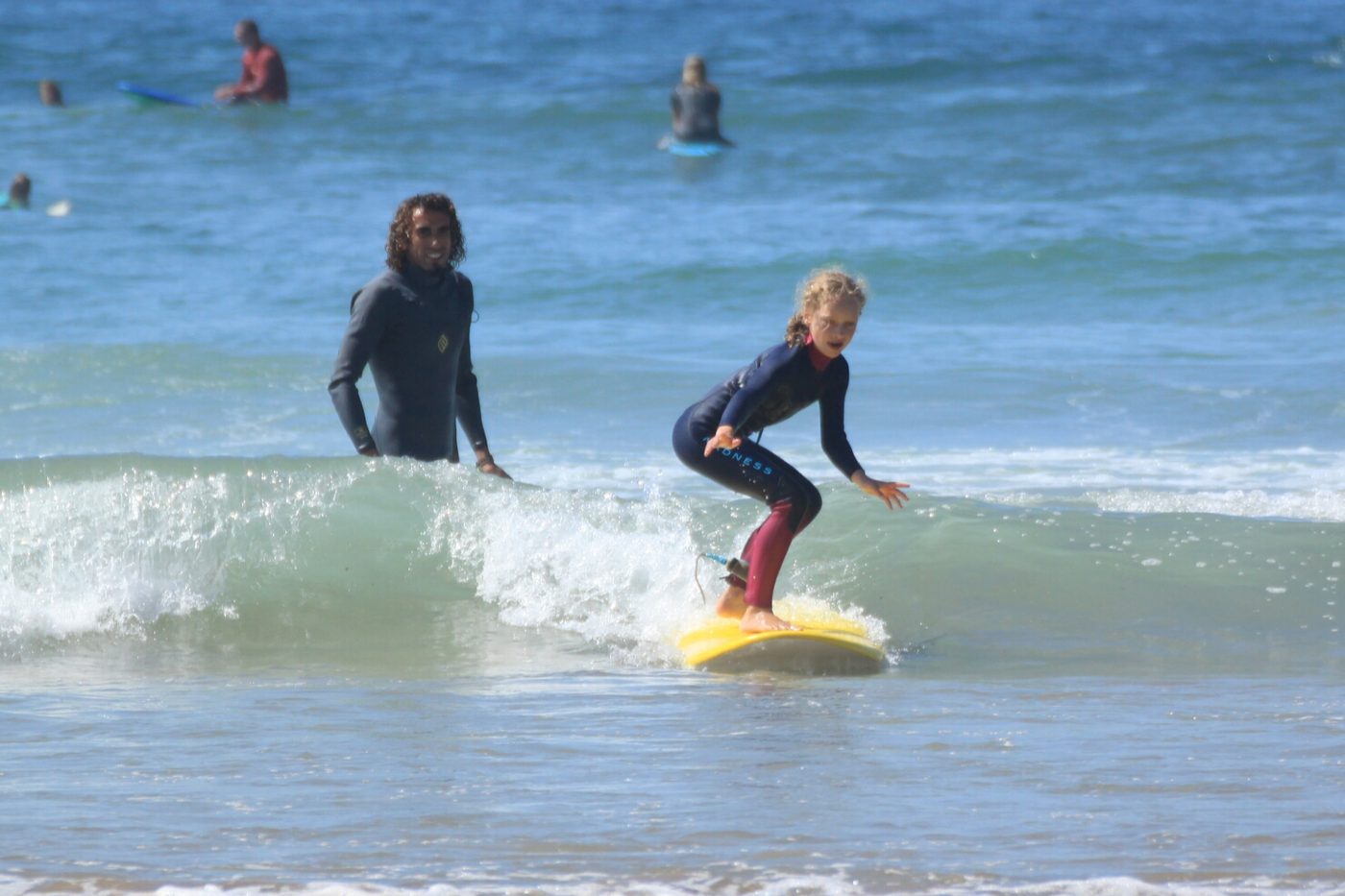 Children learning to surf on soft-top boards