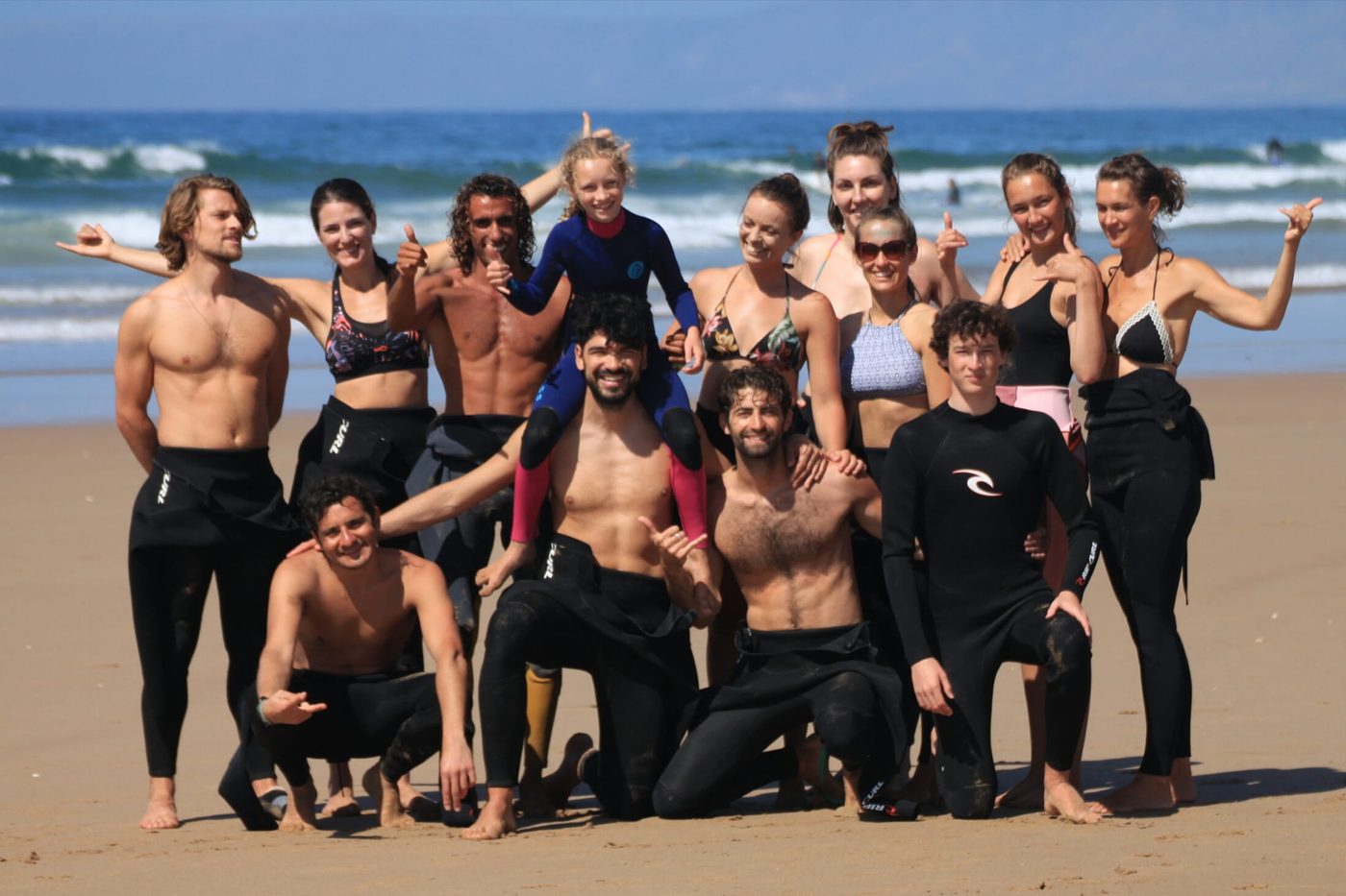 Group warm-up on the sand before paddling out, Tamraght